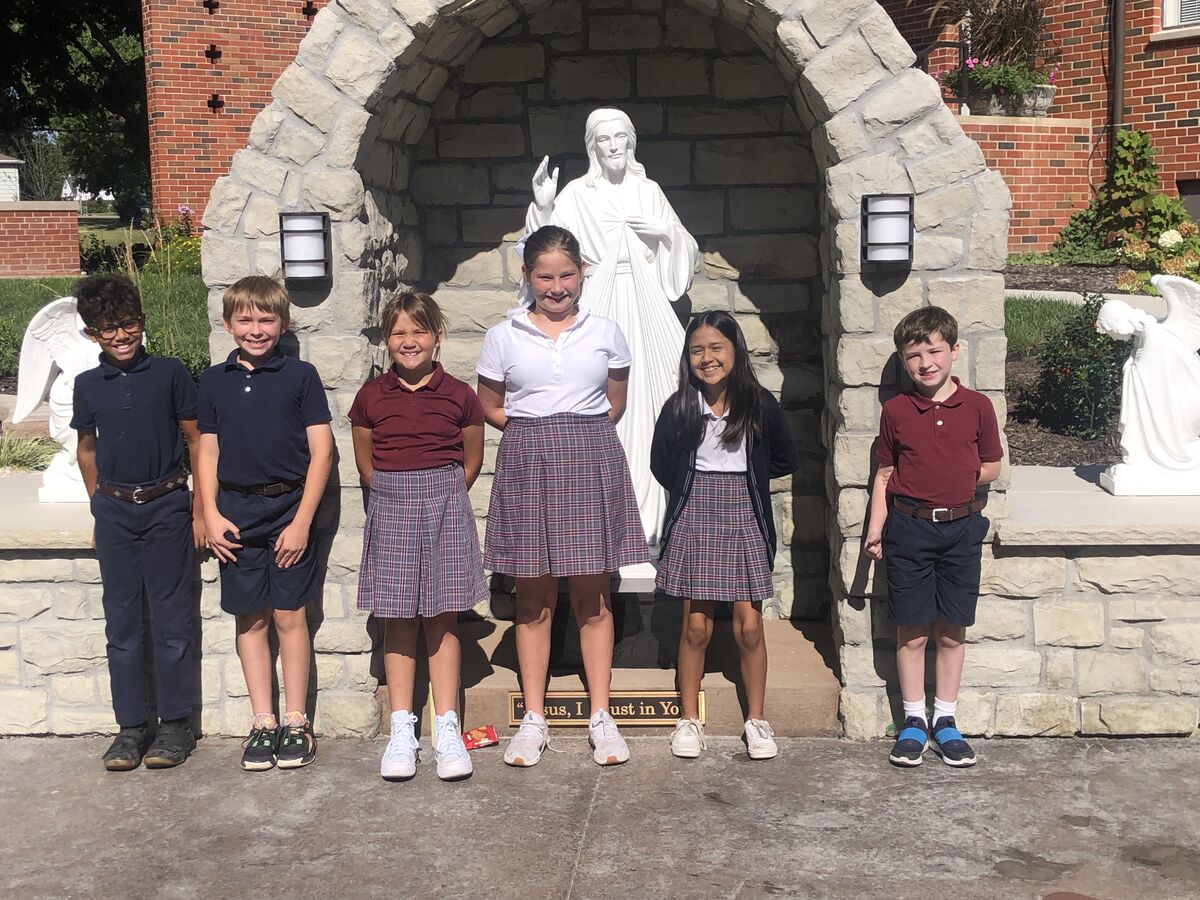 Students in front of school statue